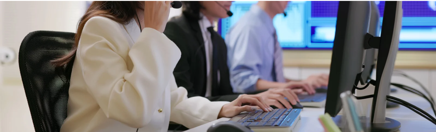 Two people pointing at a document on a table, one holding a pen